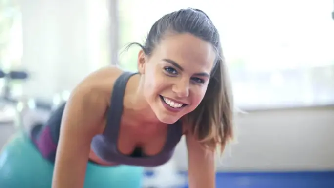 Mujer realizando un ejercicio con apoyo sobre una pelota de Pilates